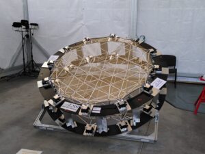 Large Space Reflector demonstrator with a segmented reflective surface supported by a geometric frame and multiple adjustment mechanisms around the perimeter.